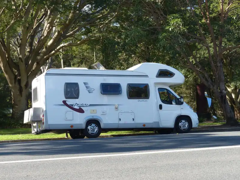 Camping-car moderne stationné sur une aire de camping avec installation électrique et fusibles de batterie cellule