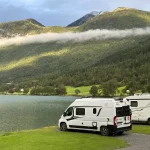 Deux camping-cars stationnés près d’un lac de montagne en Suisse lors d’un road trip