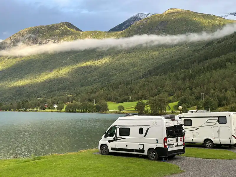 Deux camping-cars stationnés près d’un lac de montagne en Suisse lors d’un road trip