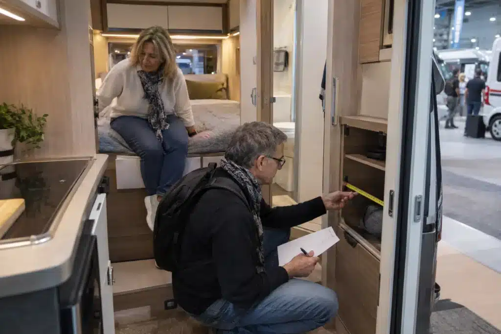 Couple vérifiant les rangements et le couchage d’un camping-car au Salon VDL 2026.